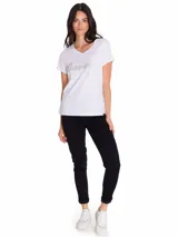 Remera de cuello en V, manga corta, color blanco con estampa metálica frontal de la marca Caterpillar.