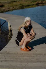 Conjunto de dos piezas tejido en algodón, compuesto por un chaleco sin mangas con cierre frontal de botones y un short de tiro medio. Ambas prendas presentan un diseño en color blanco con detalles de terminaciones en color beige.