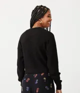 Suéter negro de punto con textura acanalada, cuello redondo y mangas largas.