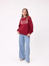 Sweater negro de corte regular con cuello redondo y puños y dobladillo acanalados con detalles de rayas grises. Presenta estampados blancos en el frente con el texto "Rusty Club" y logos de la marca.