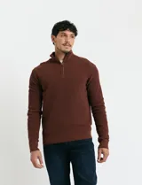 Remera de punto inglés con cierre frontal parcial y cuello alto, confeccionada en algodón con puños y cuello en punto canalé.