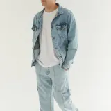 Campera de jean celeste claro con cuello clásico, cierre frontal con botones metálicos, bolsillos con solapa abotonada en el pecho y bolsillos laterales.