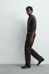 Jeans flare fit de denim negro, con tiro medio, corte ajustado en la parte superior y ligeramente acampanado desde la rodilla. Diseño de cinco bolsillos y cierre frontal con botones.