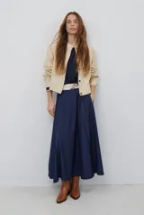 Chaqueta corta color marrón de corte recto, con cuello redondo, cierre frontal de botones y bolsillos frontales tipo parche.