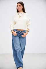 Sweater de punto con diseño de trenzas, color crudo, de cuello redondo y manga larga con puños acanalados.