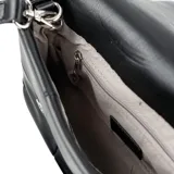 Bandolera negra de formato rectangular con diseño acolchado y solapa frontal. Cuenta con correa regulable, herrajes plateados y placa metálica con logo de la marca.