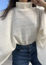 Poncho de hilo liviano en color crudo, con cuello alto y diseño de caída fluida y holgada, ideal para media estación.