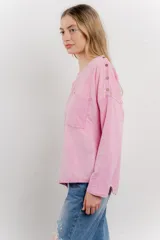 Remera manga larga color rosa con bolsillo en el pecho y corte irregular en el ruedo.