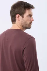 Remera de manga larga con cuello redondo, confeccionada en tejido de algodón con textura jaspeada. Presenta un pequeño logo bordado en el pecho y una etiqueta decorativa en el puño.