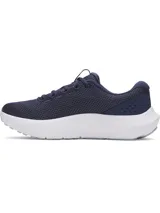 Championes de running Under Armour modelo Charged Surge 4, color azul marino con entresuela blanca y logo en celeste. Presentan parte superior de malla transpirable con refuerzos sintéticos, amortiguación Charged Cushioning en la entresuela y suela de goma resistente.