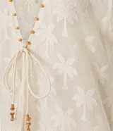 Salida de playa tipo kimono color crema con bordado de palmeras, escote en V y lazo delantero.