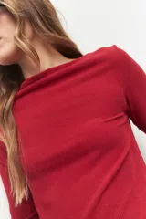 Remera negra de manga larga, cuello alto y corte diagonal en la parte inferior.