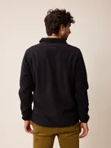 Campera de polar color beige con cierre frontal completo y cuello alto. Presenta un bolsillo en el pecho con cierre y detalle de parche con logo. El diseño combina paneles de tejido polar con detalles en tejido técnico en la zona del pecho.