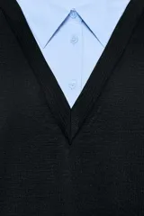 Vestido corto que combina una camisa celeste de manga larga con cuello solapa y botones frontales, con un chaleco de tejido negro sin mangas y escote en V superpuesto.