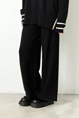 Pantalón de punto rib color beige, de corte recto y holgado, con una línea vertical lateral en color amarillo neón.