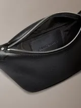 Riñonera negra Calvin Klein de poliuretano con monograma grabado en toda la pieza, correa ajustable y cierre superior con cremallera.
