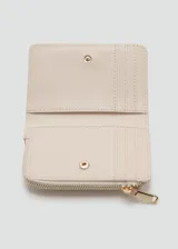 Billetera compacta de poliuretano en color beige, con diseño trenzado y cierre de cremallera superior. Cuenta con detalles metálicos dorados y el logo de la marca grabado en el frente.