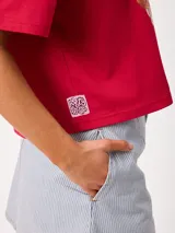 Falda corta de corte suelto, confeccionada en algodón con diseño de rayas verticales azules y blancas, bolsillos laterales y cierre frontal con botón y cremallera.