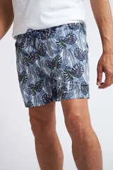 Short de baño con cintura elástica y cordón ajustable, confeccionado en tela ligera de secado rápido. Presenta un estampado botánico integral en tonos amarillos, blancos y azules, con dos bolsillos delanteros y uno posterior.