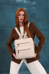 Mochila mediana de cuero sintético con textura rugosa, cuenta con dos compartimentos frontales con cierre, asa superior y correas ajustables.