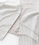 Blusa sin mangas, estilo chaleco, confeccionada en viscolino con estampado de rayas verticales finas. Presenta escote en V con amarras ajustables en el centro del busto.