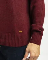 Buzo tejido de punto con cuello redondo, manga larga y puños y ruedo acanalados. Presenta un diseño clásico y versátil con un pequeño detalle de etiqueta en el lateral inferior.