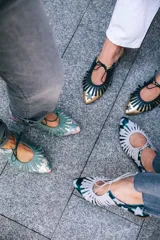 Zapato tipo blucher de cuero con acabado metalizado en color azul petróleo y estampado de estrellas blancas. Presenta un diseño con flecos decorativos en la parte frontal, cierre con cordones y suela plana de cuero.