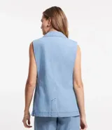 Chaleco largo de jean celeste con escote en pico y cierre con un botón marrón.