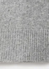Vestido corto de punto color gris, de corte recto, con cuello vuelto y manga larga.