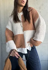 Sweater de punto con diseño de bloques de color en tonos camel y crudo, de corte holgado, cuello redondo y mangas largas con puños anchos.