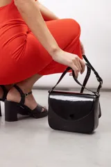 Bandolera compacta de cuero vacuno color gris con efecto gastado, solapa redondeada y correa ajustable.