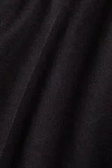 Body negro con escote asimétrico de un hombro, bretel ancho con detalle de nudo y diseño colaless.