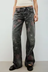 Jeans de tiro bajo y corte holgado de denim negro, con estampado floral en tonos rosados y verdes. Cuenta con diseño de cinco bolsillos y trabillas para cinturón.