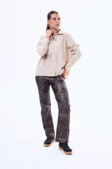 Pantalón de corte recto y tiro alto, confeccionado en material con acabado engomado o efecto cuero, en color negro. Presenta diseño de cinco bolsillos y cierre frontal con botón y cremallera.