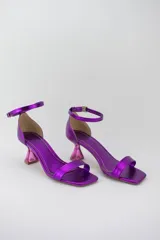 Sandalias negras con punta cuadrada, tira delantera fina y pulsera ajustable al tobillo. Destacan por su taco geométrico transparente de altura media.