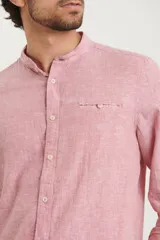 Camisa de cuello mao y manga larga, confeccionada en una mezcla de lino y algodón. Presenta un diseño de corte recto con botones en tono natural y un bolsillo pequeño en el pecho.