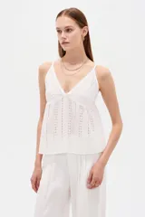 Musculosa blanca de algodón con diseño de broderie, escote en V, tirantes finos regulables y corte holgado.