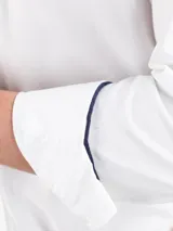 Camisa blanca de algodón con cuello button-down, corte regular fit, manga larga con puños simples y logo bordado en el pecho.