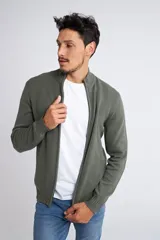 Campera tejida de punto en color verde militar, con cierre frontal completo, cuello elevado y ajuste regular. Presenta un diseño texturizado con logo bordado en el pecho y puños acanalados.