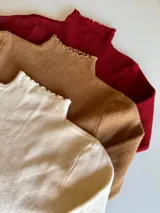 Pack de tres poleras de tejido de punto fino, con cuello alto y terminaciones con borde ondulado. Incluye tres unidades en colores natural, bordó y dulce de leche.