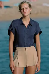 Camisa fluida oversize de lyocell color azul marino, con cuello solapa, manga corta tipo murciélago y cierre frontal con botones.
