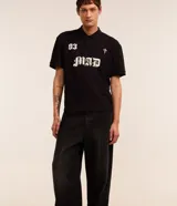 Pantalon de jean negro de corte super baggy, con tiro alto, frisos decorativos y efecto desgastado. Posee cintura con trabillas, cierre frontal tradicional y bolsillos laterales.
