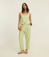 Pantalón zanahoria de vestir color verde claro, de tiro alto, con pliegues y bolsillos laterales.