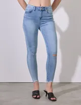 Jean skinny celeste con roturas en las rodillas y terminación desflecada.