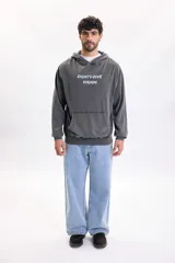 Hoodie de color gris oscuro con efecto lavado, capucha y bolsillo tipo canguro. Presenta una gran estampa en la espalda con la inscripción 'Eighty-Five Vision', una fotografía en blanco y negro de un automóvil clásico y texto descriptivo.