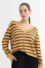 Sweater de tejido de punto color mostaza con rayas horizontales en azul marino. Presenta escote en V y mangas largas con puños acanalados.