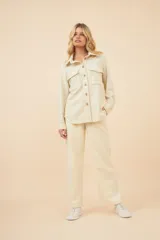 Camisa estilo leñador color beige con textura en espiga, de manga larga, con cuello clásico, cierre frontal con botones, dos bolsillos de parche con solapa abotonada en el pecho y puños abotonados. Confeccionada en lana fina sin teñir.