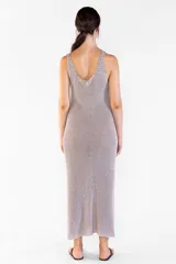 Vestido largo de punto con hilos en dos tonos que generan un efecto jaspeado, escote bote, sin mangas y aberturas laterales en el dobladillo.