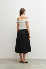 Vestido midi de corte recto, con top blanco de escote bardot y falda negra.