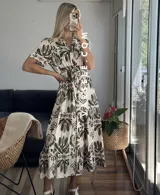 Vestido midi con estampado floral en tonos marrones y beige, corte camisero con cuello en V y botones frontales.